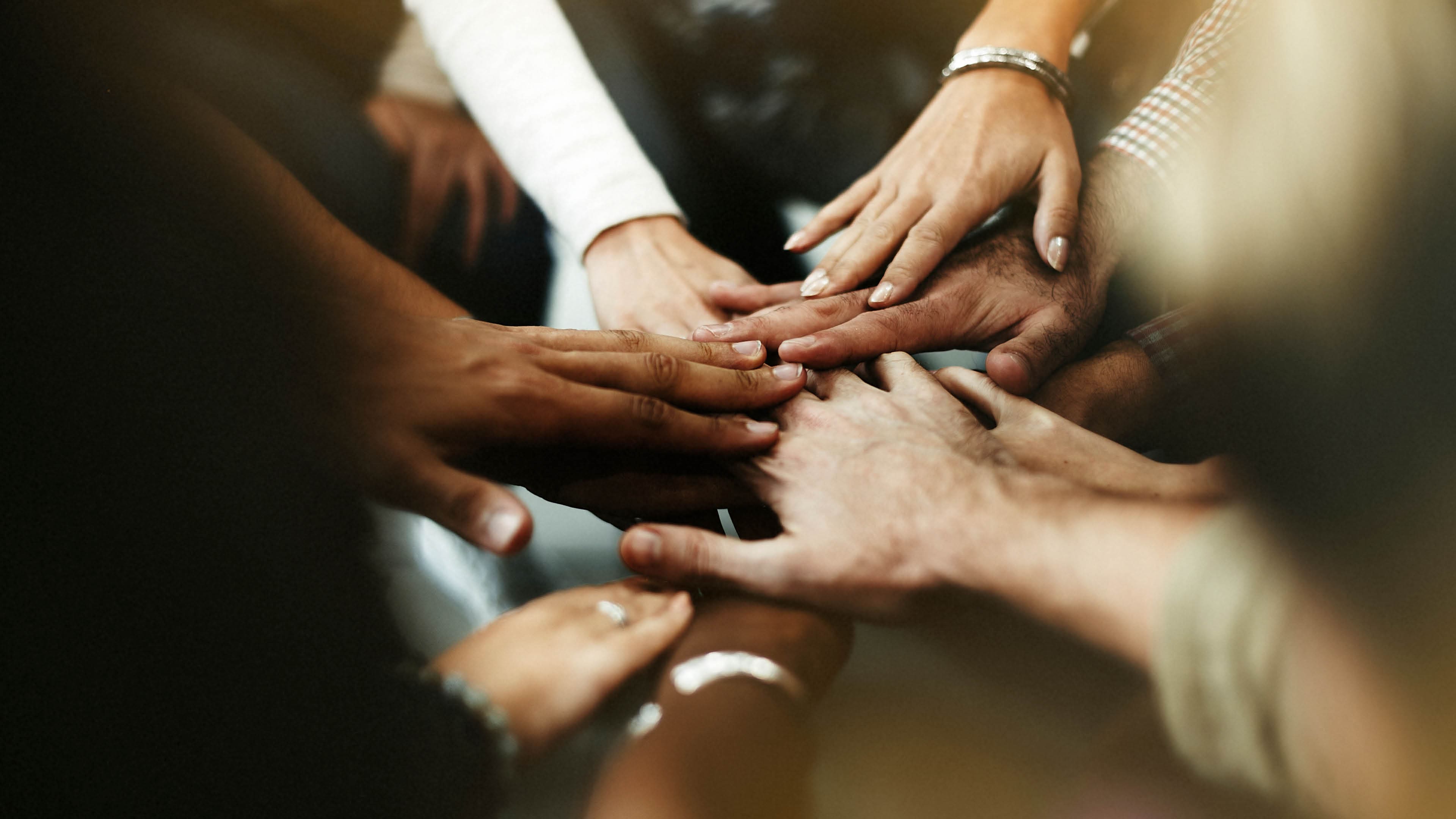 Closeup of diverse people joining their hands
